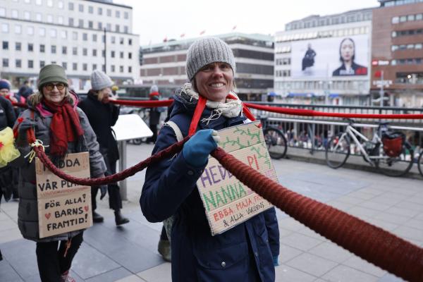 Klimato aktyvistės apjuosė Švedijos parlamentą milžinišku raudonu šaliku