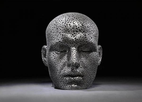 Masyvios žmogaus galvos skulptūros iš dviračių grandinių, vaizduojančios mūsų šiuolaikinius suvaržymus